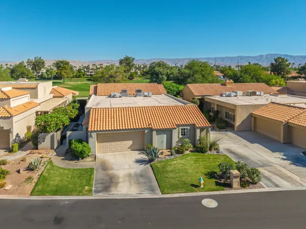 an aerial view of a house with a yard and lake view