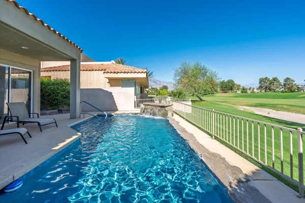 a view of a patio with lawn chairs floor to ceiling window and yard