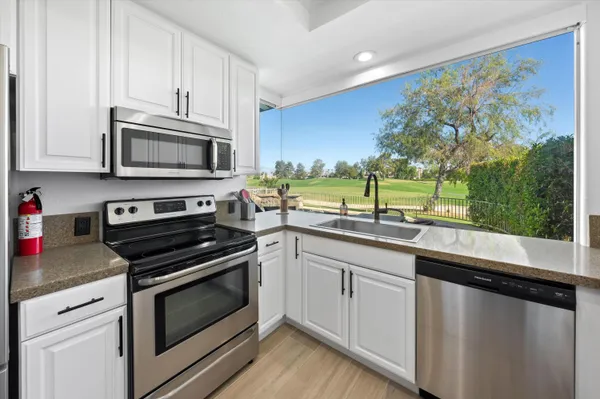 a kitchen with stainless steel appliances granite countertop a stove and a microwave