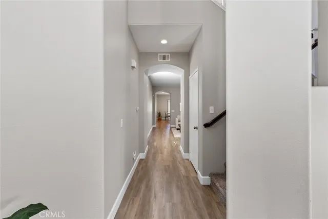 a open kitchen with stainless steel appliances granite countertop a stove a refrigerator a kitchen island a dining table and chairs with wooden floor