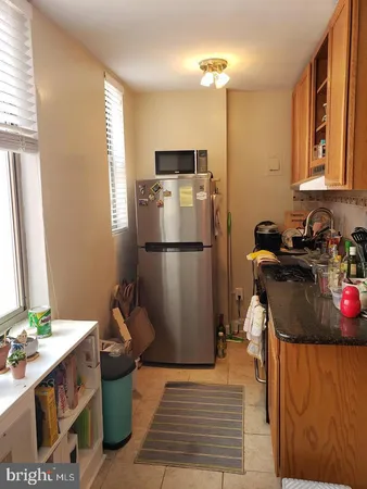 a kitchen with stainless steel appliances granite countertop a refrigerator and a sink
