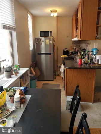 a kitchen with stainless steel appliances granite countertop a refrigerator a stove and a sink