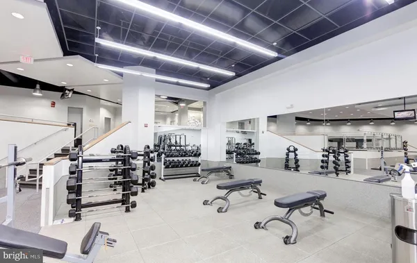 a gym room with lots of chairs and mirrors