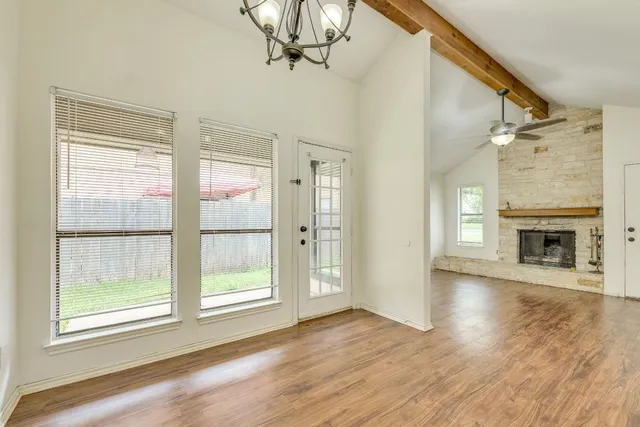 a view of empty room with wooden floor and fireplace