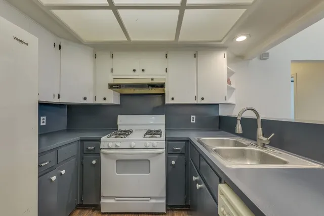 a kitchen with stainless steel appliances granite countertop a sink a stove and a refrigerator