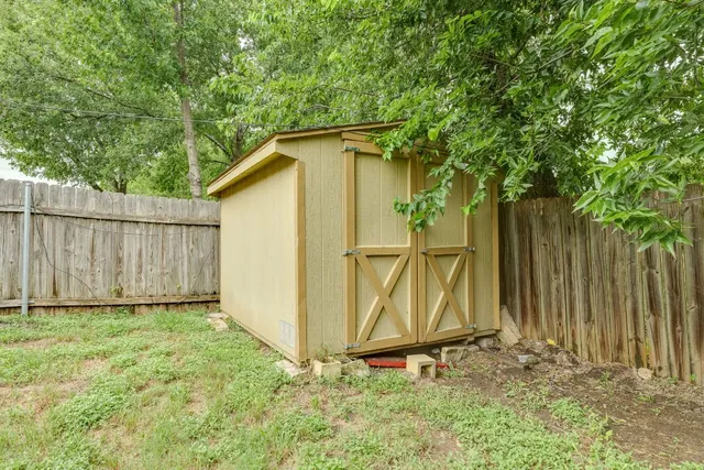 a backyard of a house with plants and wooden fence