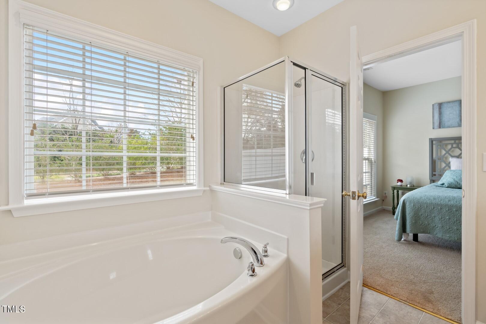 12219 Fox Valley Street Raleigh, NC 27614 - Photo 19 of 36 a bathroom with a bathtub and a window