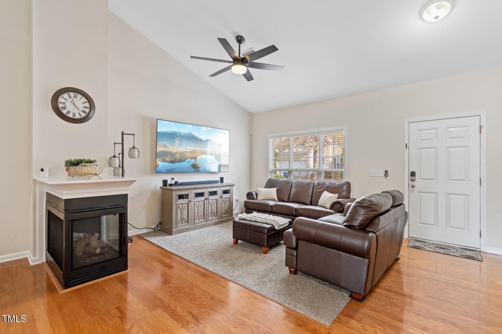12219 Fox Valley Street Raleigh, NC 27614 - Photo 2 of 36 a living room with furniture a clock and a fireplace