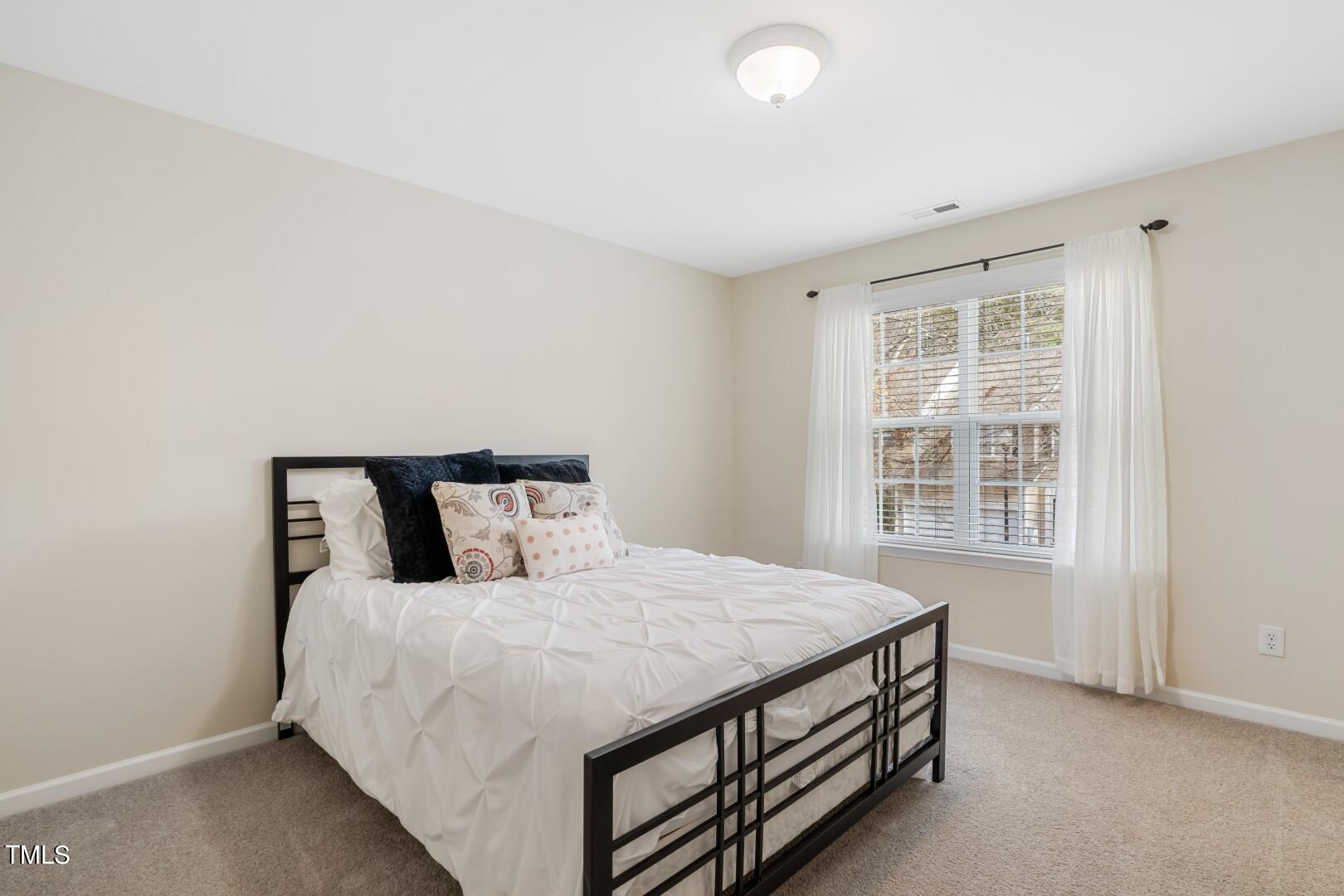 12219 Fox Valley Street Raleigh, NC 27614 - Photo 24 of 36 a bed sitting in a spacious bedroom next to a window