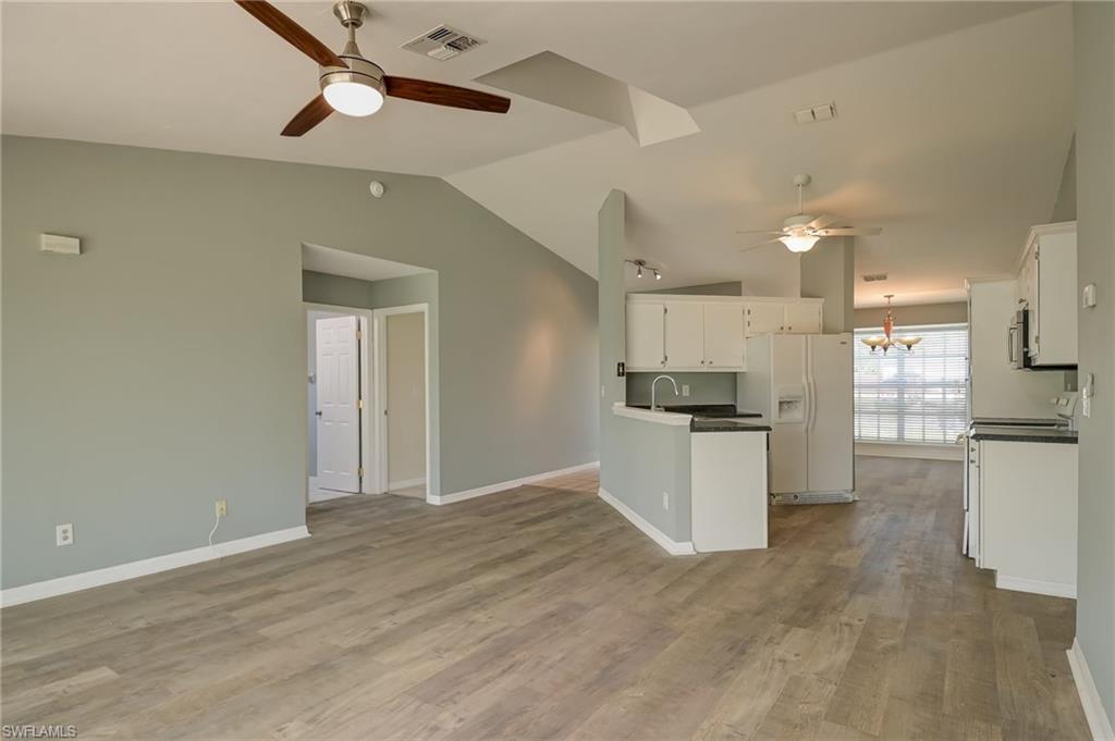 17437 Lee Road Fort Myers, FL 33967 - Photo 4 of 23 a kitchen with a refrigerator and white cabinets