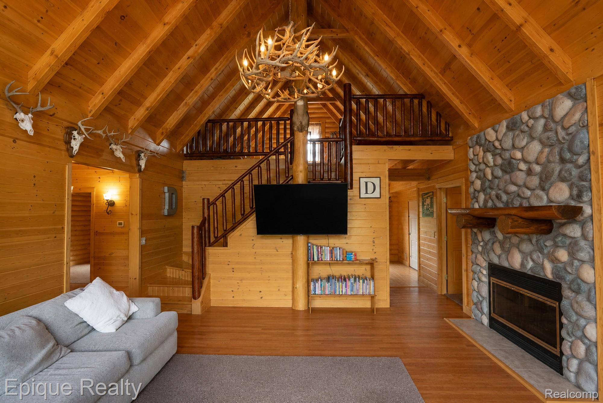 1966 Mayer Road Smiths Creek, MI 48074 - Photo 17 of 38 Vaulted wood-finish ceilings and walls define this living space, featuring a prominent stone-clad fireplace with a natural wood mantel
