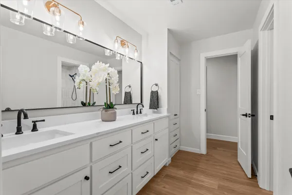 a bathroom with double sink and a mirror