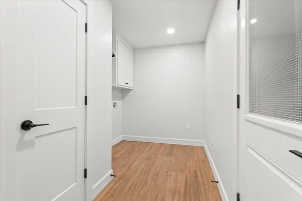 a view of a hallway with wooden floor and a staircase