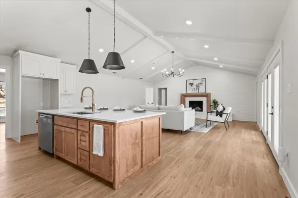 a large kitchen with stainless steel appliances a large center island and a wooden floors