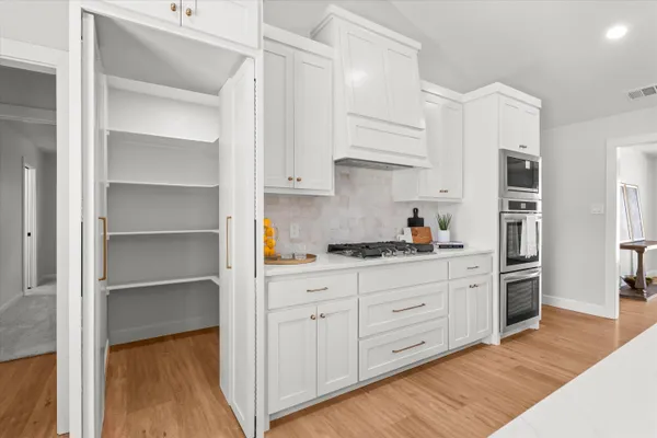 a kitchen with stainless steel appliances granite countertop a refrigerator and a stove top oven