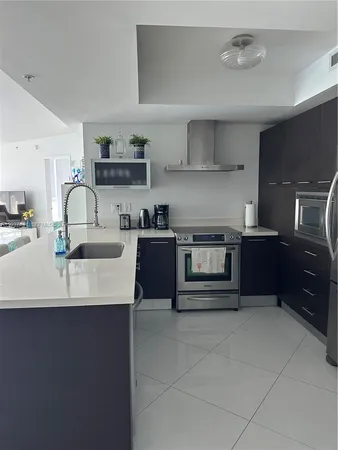 a kitchen with kitchen island granite countertop a sink stove and cabinets