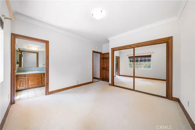 a living room with furniture potted plant and kitchen view