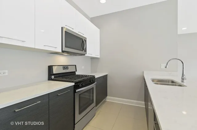 a kitchen with stainless steel appliances granite countertop a sink stove and microwave