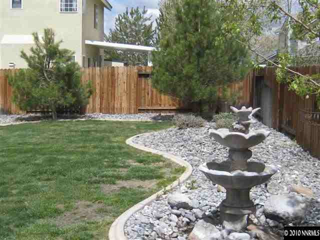 9680 North Legacy Court Reno, NV 89521 - Photo 9 of 9 a view of a backyard with table and chairs potted plants and wooden fence