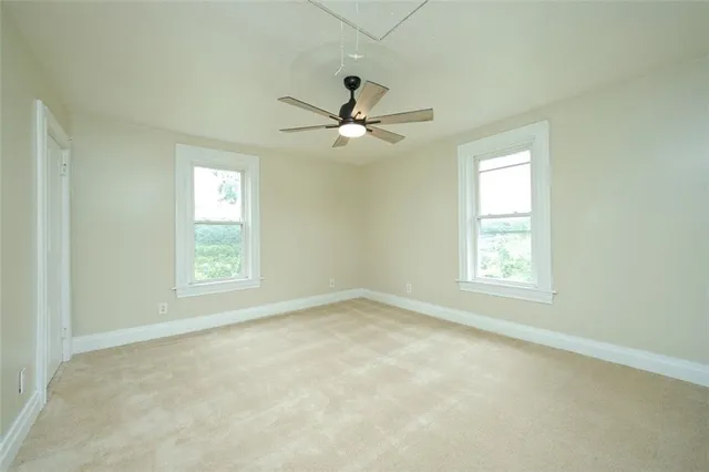 an empty room with a window and a fan