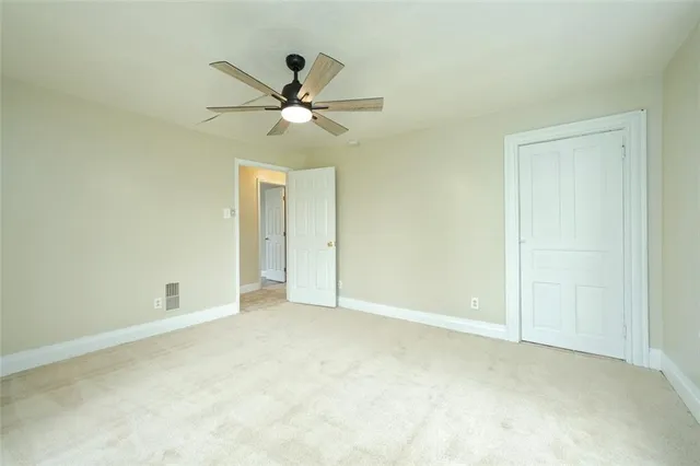an empty room with a ceiling fan and a window
