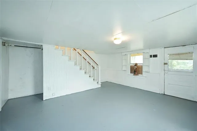 a view of an empty room with wooden floor and windows