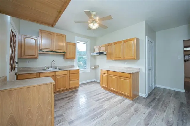 a kitchen with granite countertop a stove cabinets and wooden floor