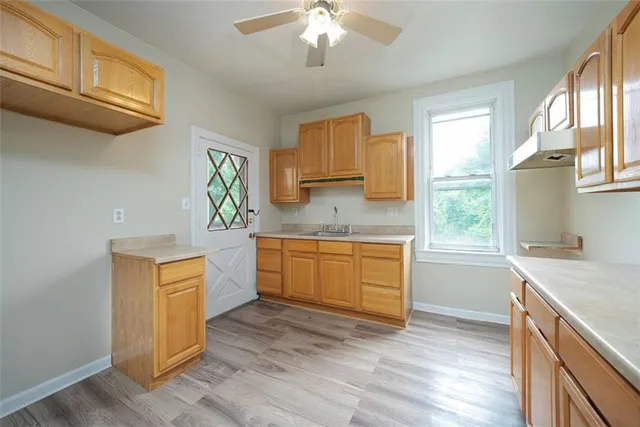 a kitchen with granite countertop a stove cabinets and wooden floor