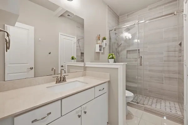 a bathroom with a sink shower and a mirror