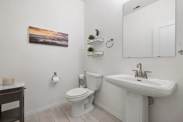 a bathroom with a sink a toilet and mirror