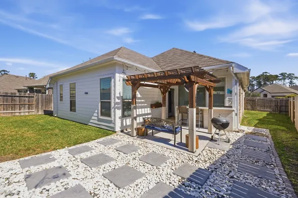 a view of a house with backyard sitting area and garden