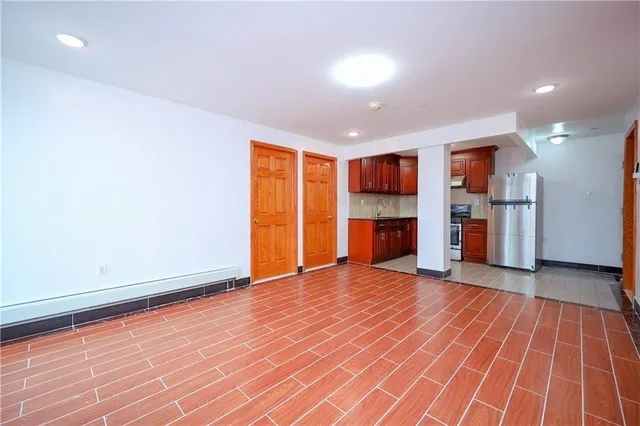 wooden floor in an empty room with a kitchen
