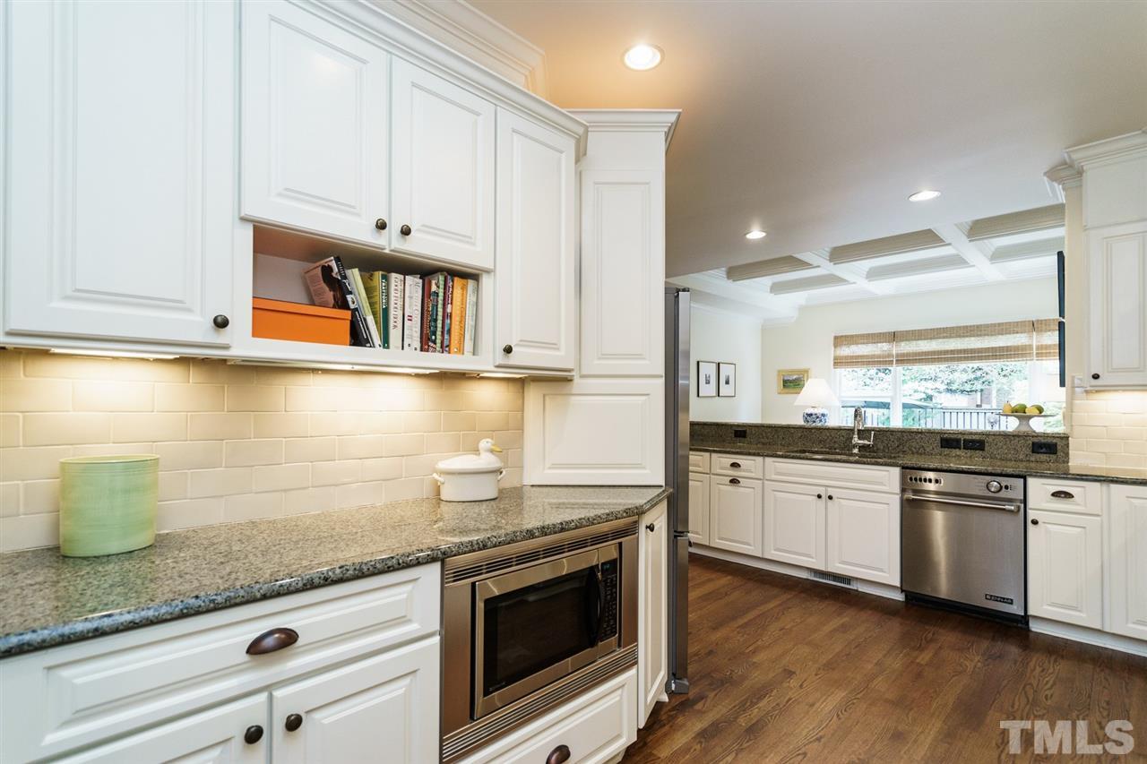 1820 Torrington Street Raleigh, NC 27615 - Photo 11 of 25 a kitchen with stainless steel appliances granite countertop a sink a stove and a wooden floors