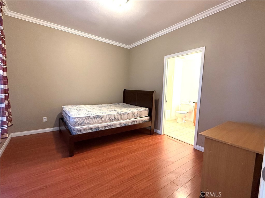 13645 Foster Avenue, Unit 4 Baldwin Park, CA 91706 - Photo 14 of 19 a bedroom with a bed and wooden floor