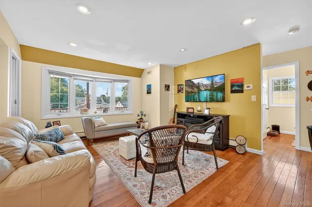 a kitchen with a dining table wooden floor and stainless steel appliances