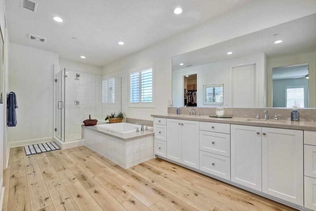 665 Gemstone Drive San Marcos, CA 92078 - Photo 18 of 49 a spacious bathroom with a double vanity sink a mirror and a bathtub