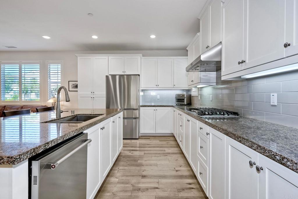 665 Gemstone Drive San Marcos, CA 92078 - Photo 10 of 49 a large kitchen with stainless steel appliances granite countertop a stove a sink dishwasher and a refrigerator