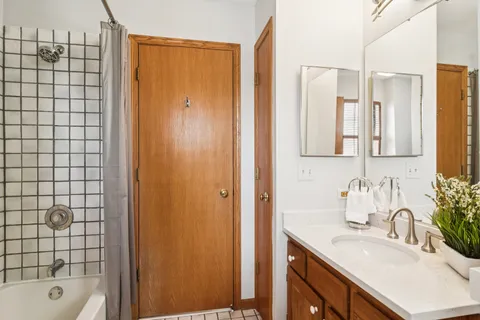 a bathroom with a granite countertop sink a mirror a shower and a bathtub