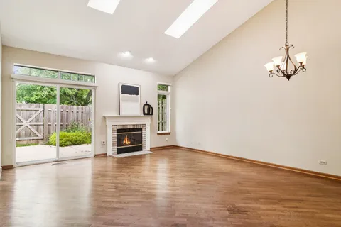 a view of a livingroom with a fireplace wooden floor and window