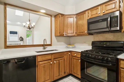 a kitchen with stainless steel appliances granite countertop a sink stove and microwave