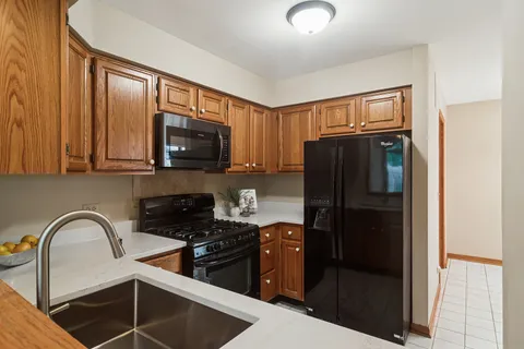 a kitchen with stainless steel appliances granite countertop a refrigerator a stove a sink and dishwasher