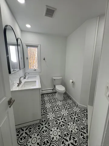 a bathroom with a sink toilet and mirror