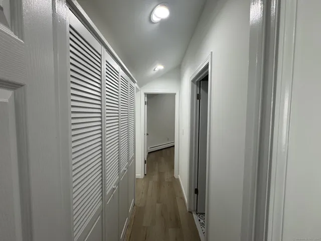 a view of a hallway with wooden floor and staircase