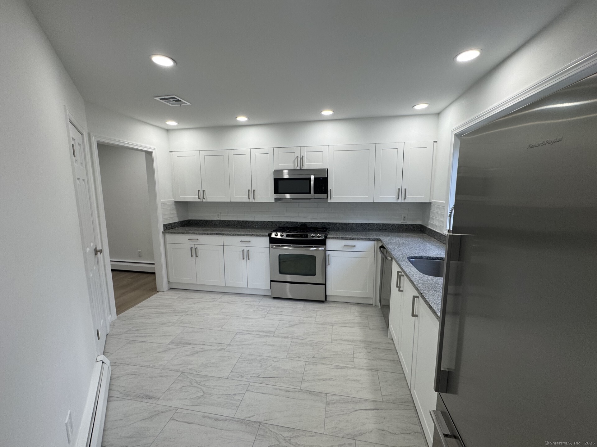 4 Earls Court, Unit C Farmington, CT 06032 - Photo 2 of 18 a kitchen with stainless steel appliances granite countertop a stove a sink and a refrigerator