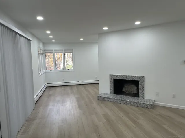 an empty room with wooden floor and fireplace