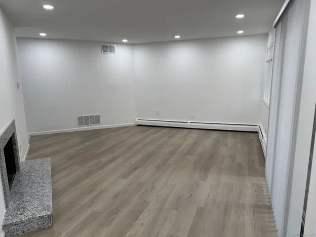an empty room with wooden floor and a window
