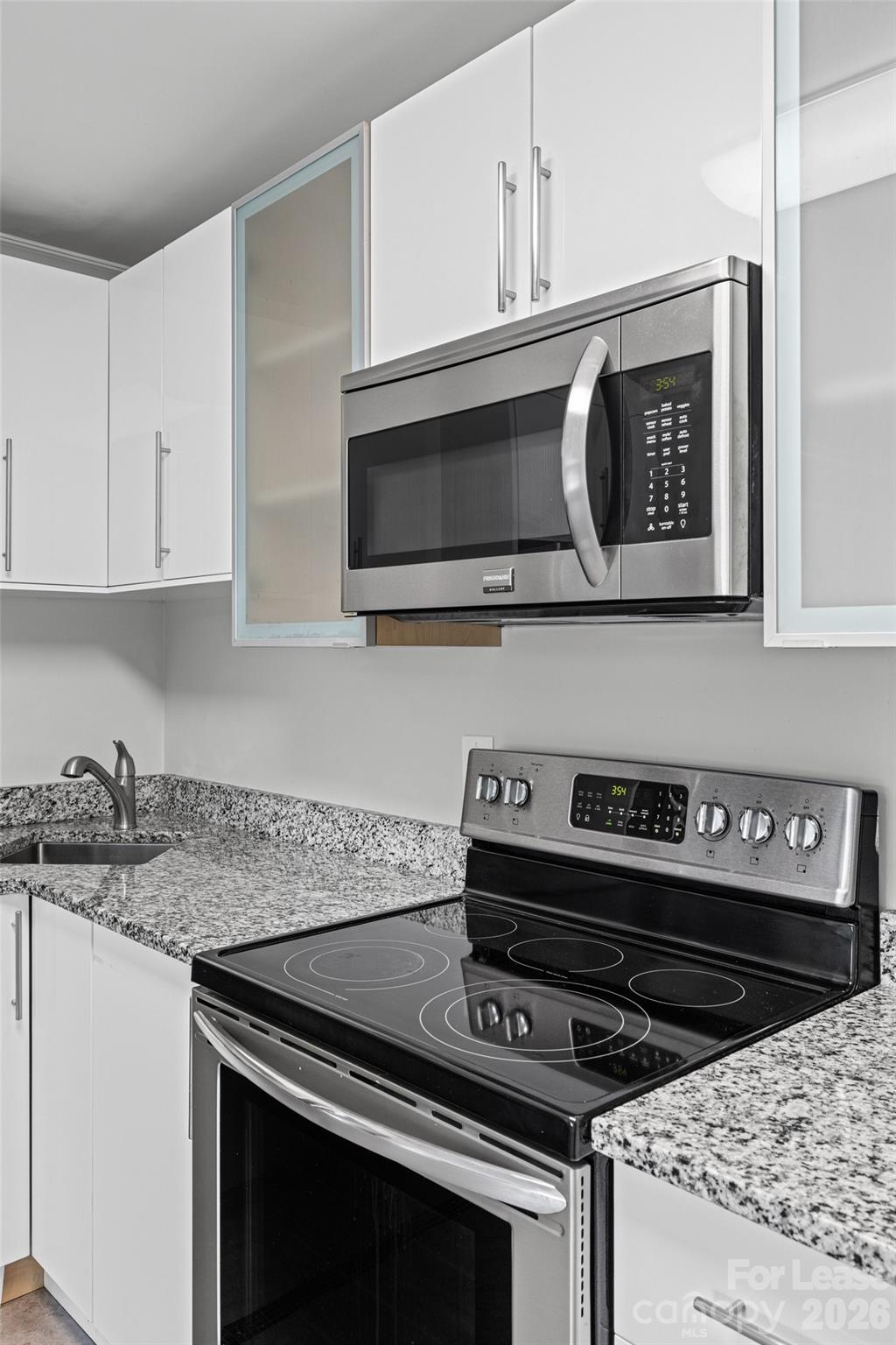 113 Stroupe Road, Unit E Gastonia, NC 28056 - Photo 12 of 32 a kitchen with stainless steel appliances granite countertop white cabinets and black stove top oven with granite countertops