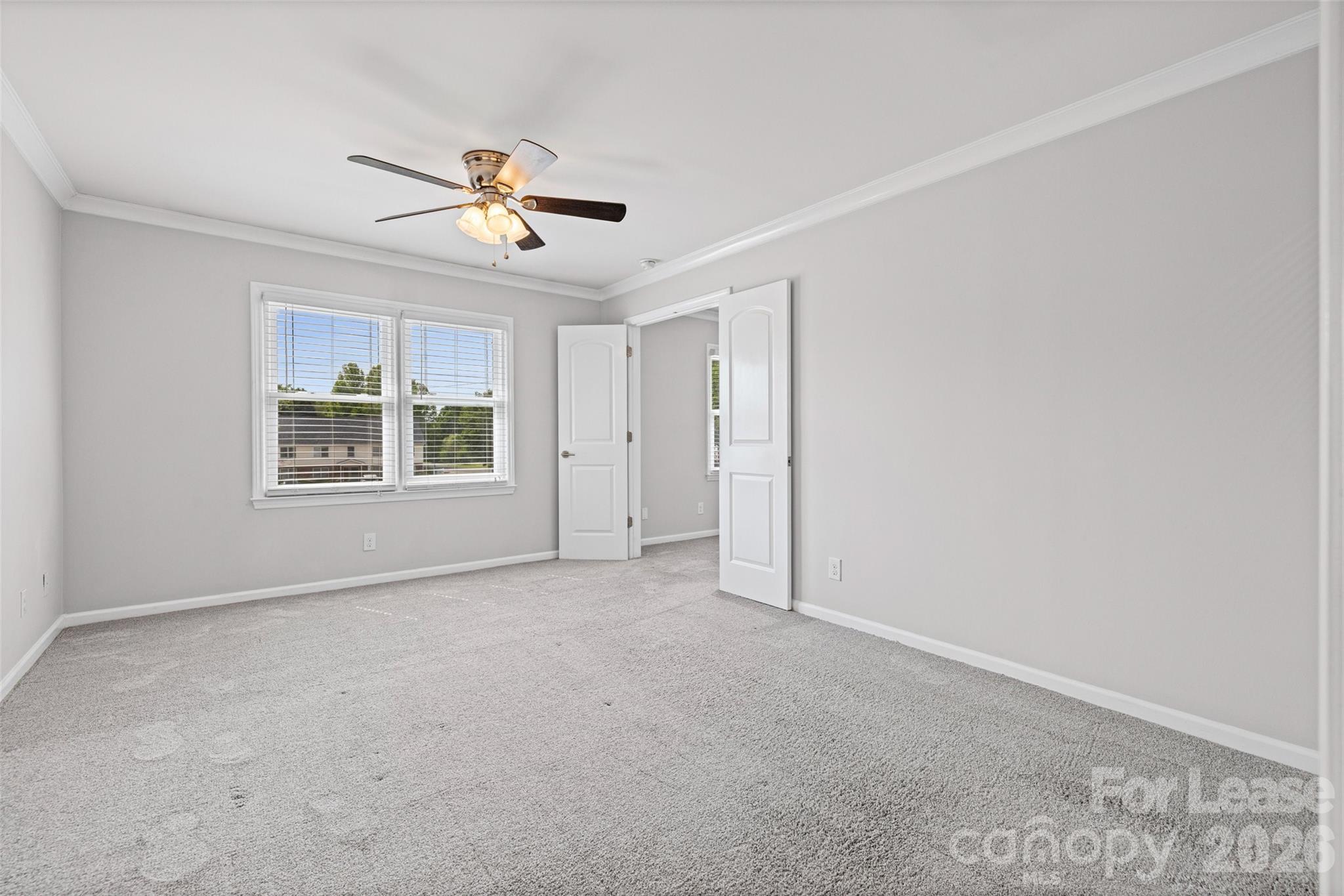 113 Stroupe Road, Unit E Gastonia, NC 28056 - Photo 19 of 32 an empty room with windows and ceiling fan