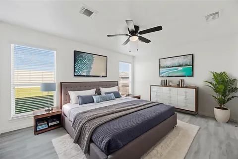 a bedroom with a large bed a chandelier and a potted plant