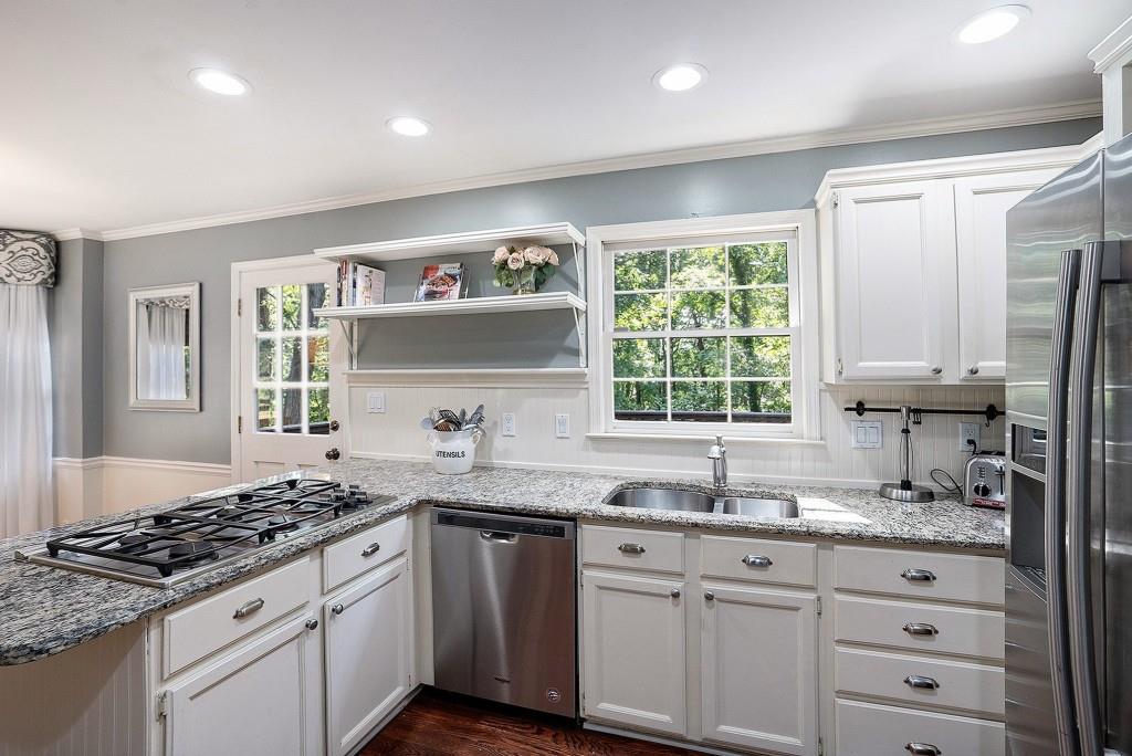 4682 Bentley Place Peachtree Corners, GA 30096 - Photo 14 of 44 a kitchen with granite countertop a sink stove and cabinets